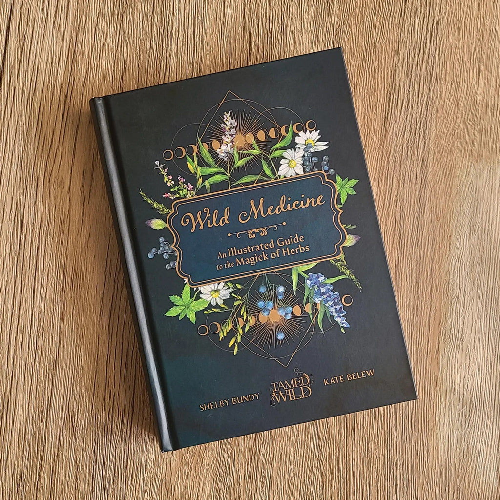 Book titled 'Wild Medicine' with floral design on a wooden surface