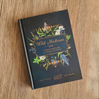 Book titled 'Wild Medicine' with floral design on a wooden surface