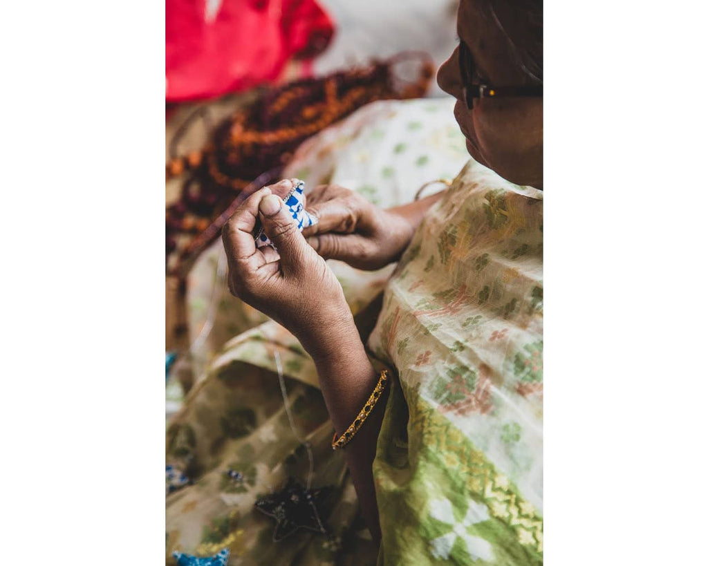 Image of an Indian woman crafting the Embroidered Star Garland by hand