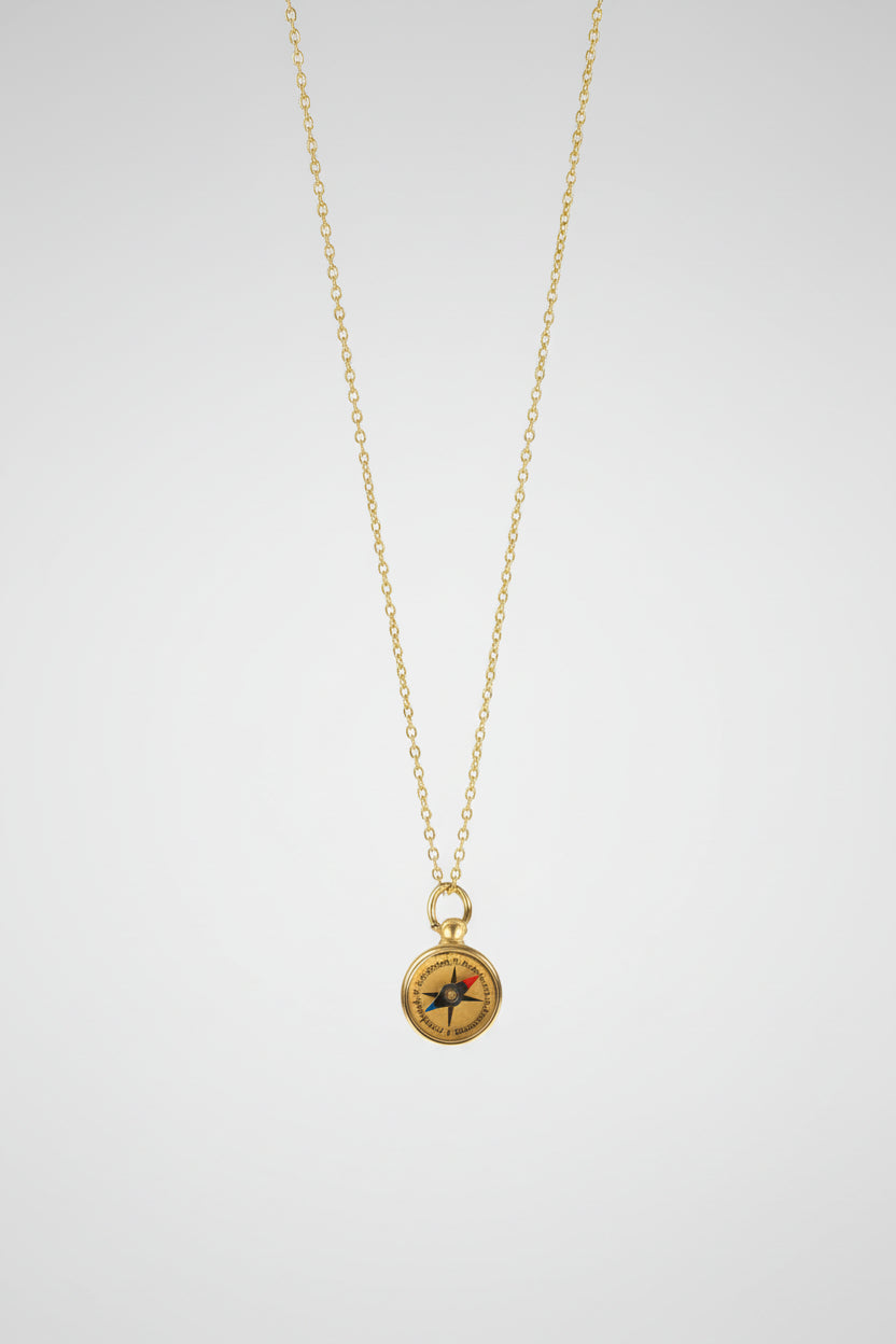 Gold necklace with a compass pendant on a white background