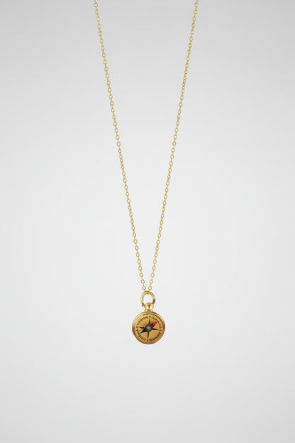 Gold necklace with a compass pendant on a white background