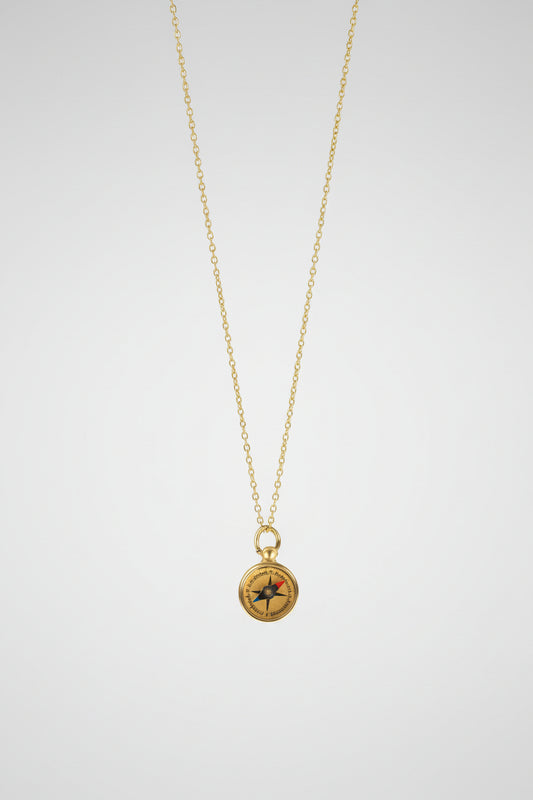 Gold necklace with a compass pendant on a white background