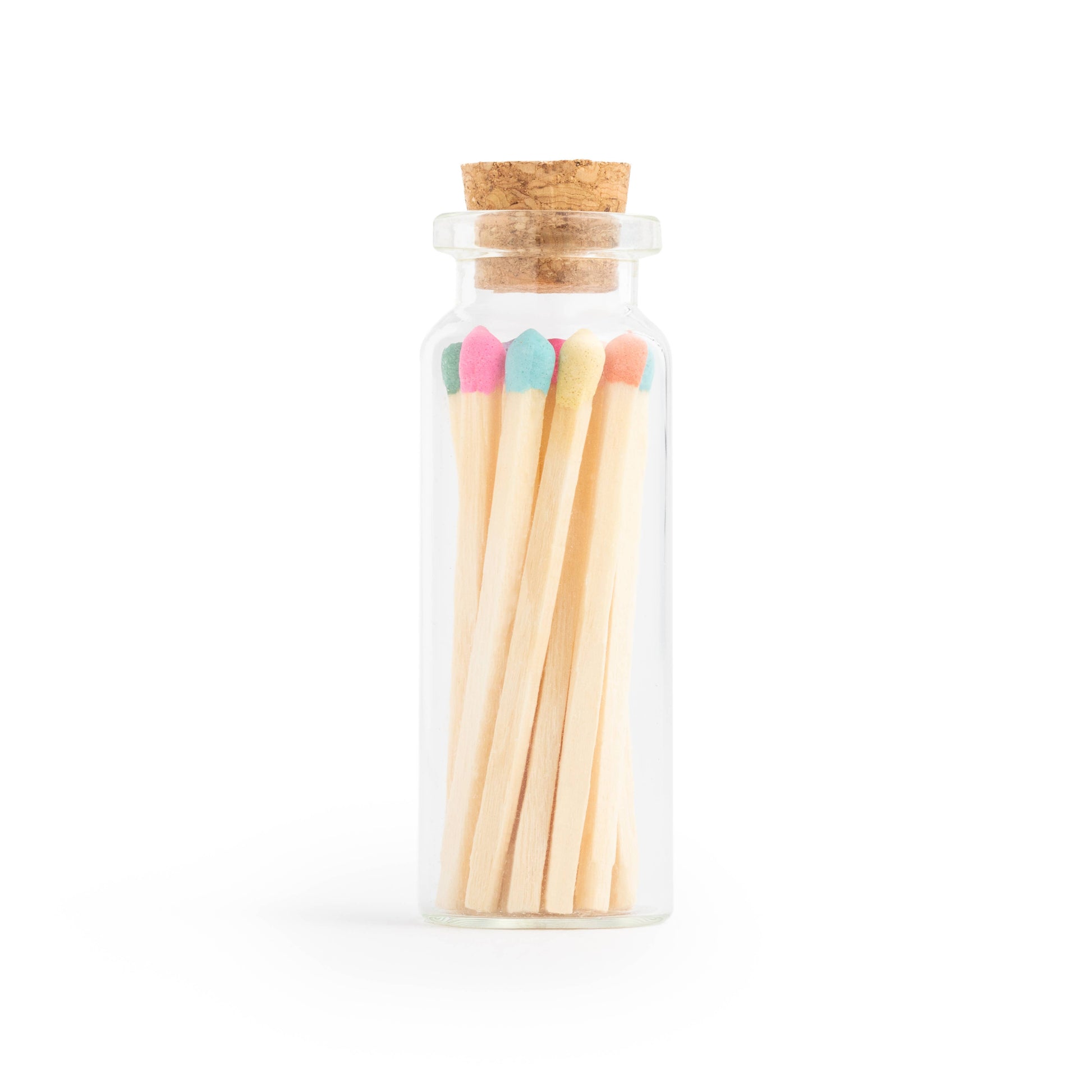 Birthday cake scented candle in white tin with corked vial of colorful matchsticks, packaged in a clear vinyl gift box.