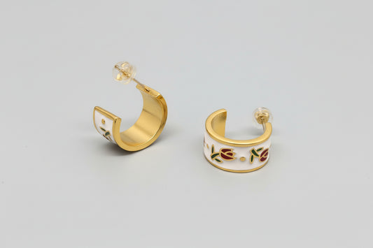 Gold hoop earrings with colorful designs on a gray background