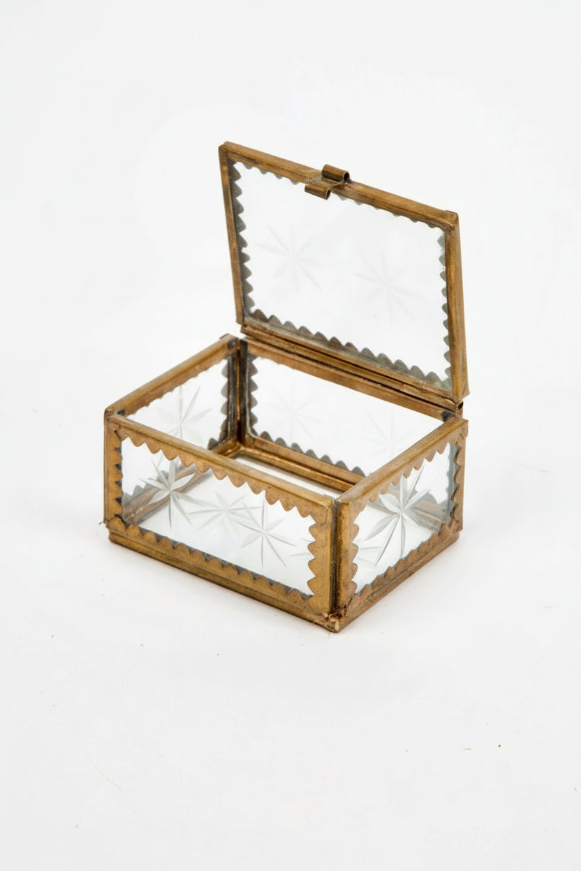 A brass and etched glass box, perfect for holding jewelry on a white background