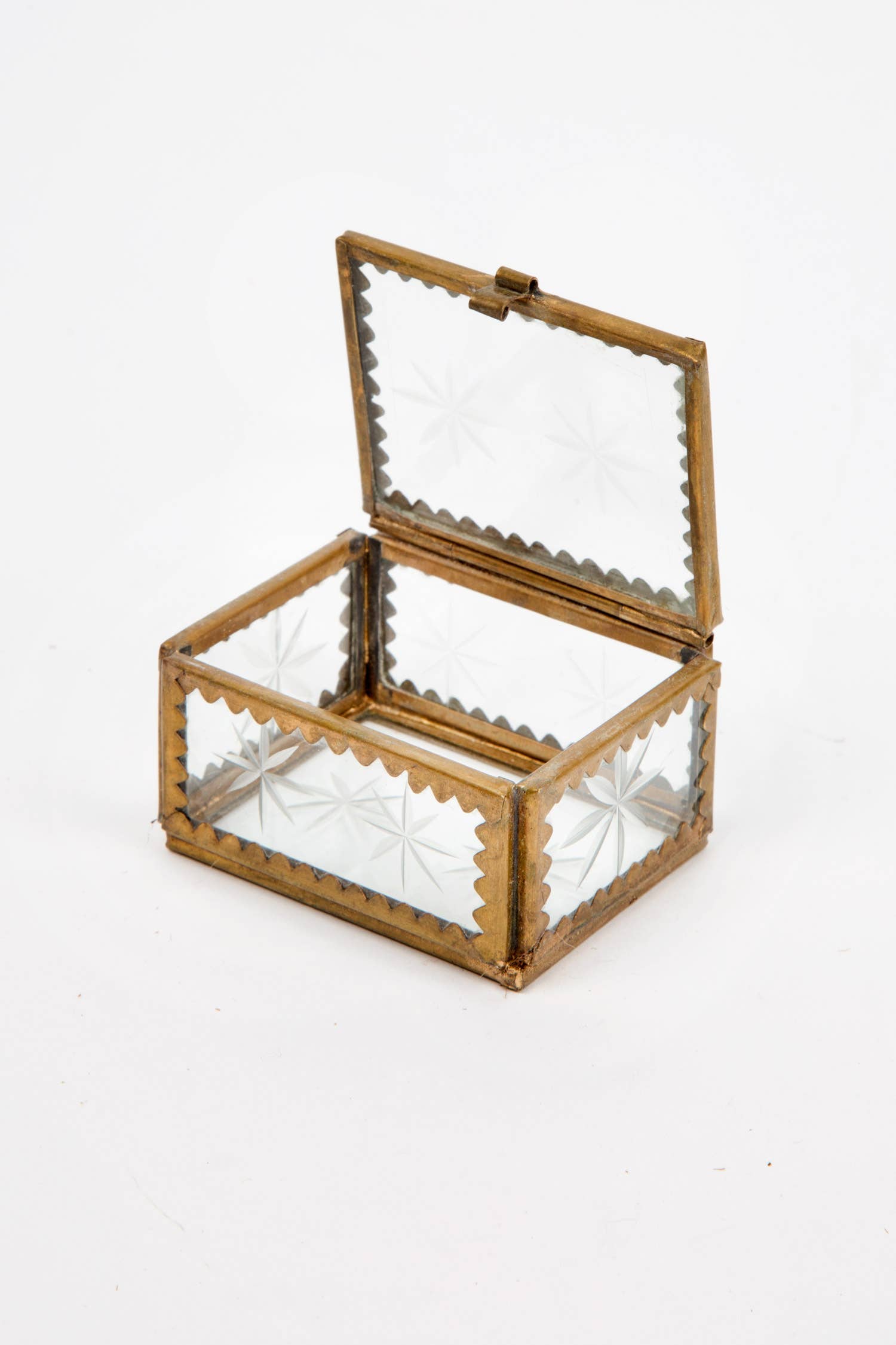A brass and etched glass box, perfect for holding jewelry on a white background