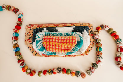 Colorful stack of pouches with patterned contents on a white background