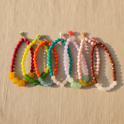 Set of colorful beaded bracelets on a textured natural background