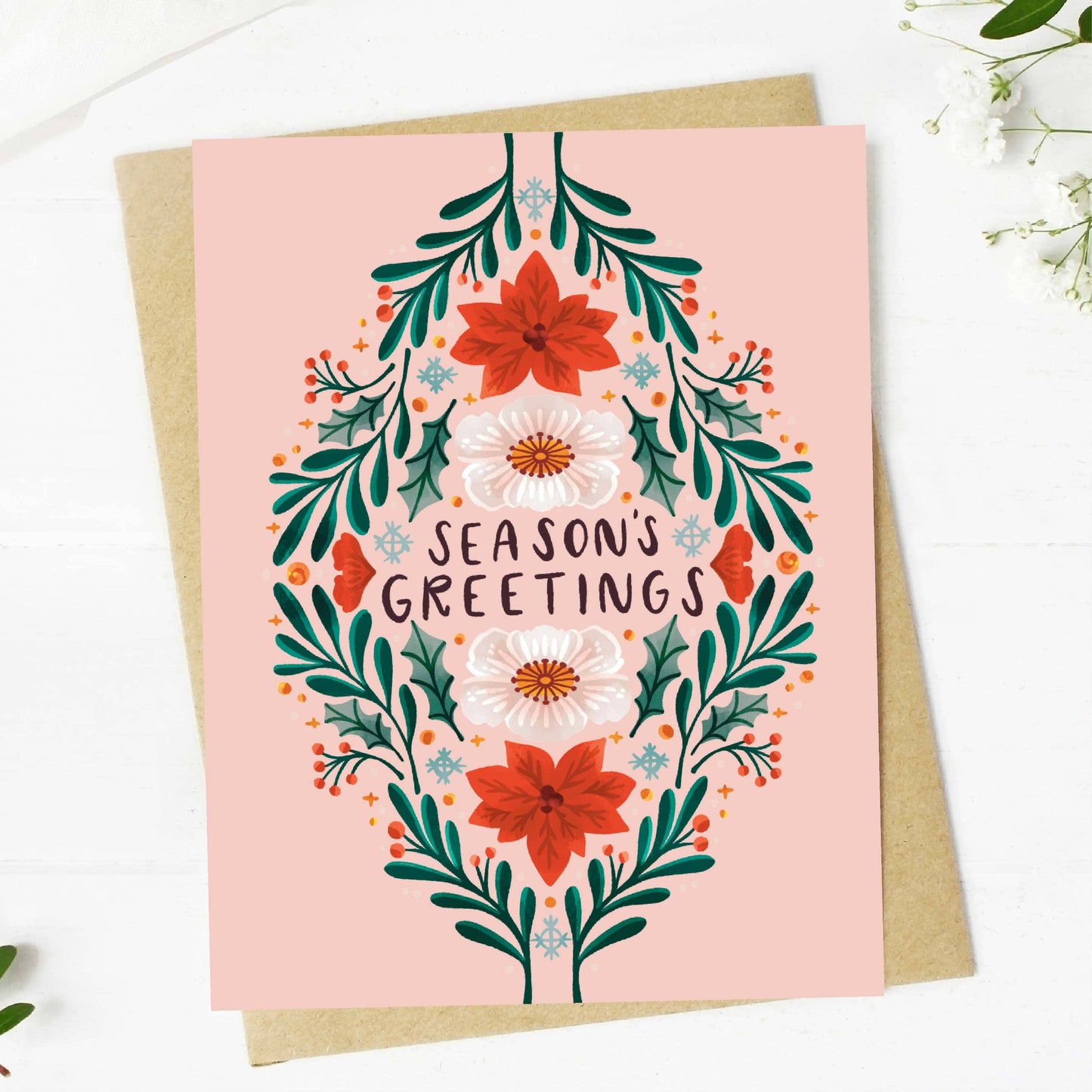 Greeting card with floral design and 'Season's Greetings' text on a pink background
