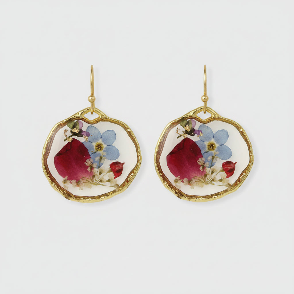 Close-up of pink, red, blue, and purple flowers inside circular resin earrings
