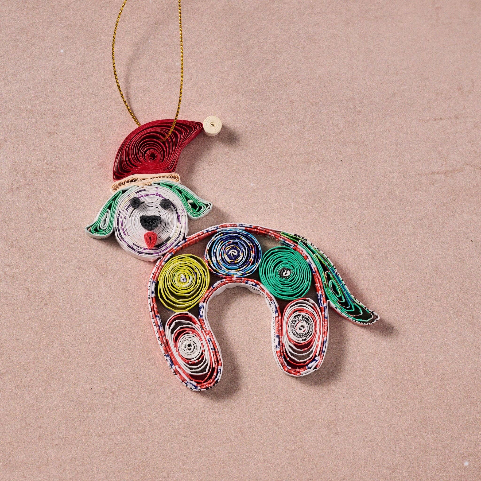 Colorful paper quilled dog ornament laid flat on a natural stone counter