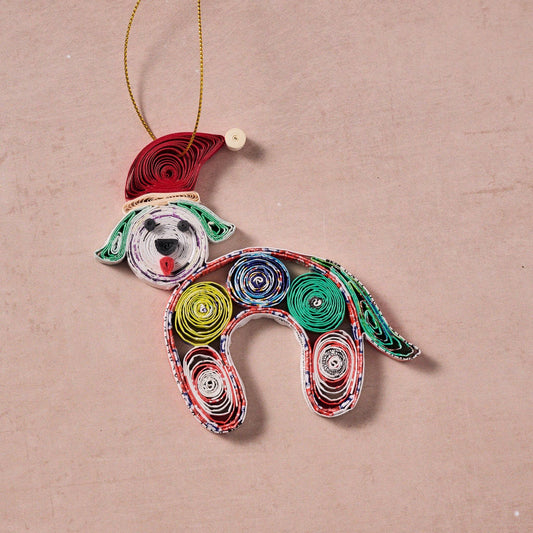 Colorful paper quilled dog ornament laid flat on a natural stone counter