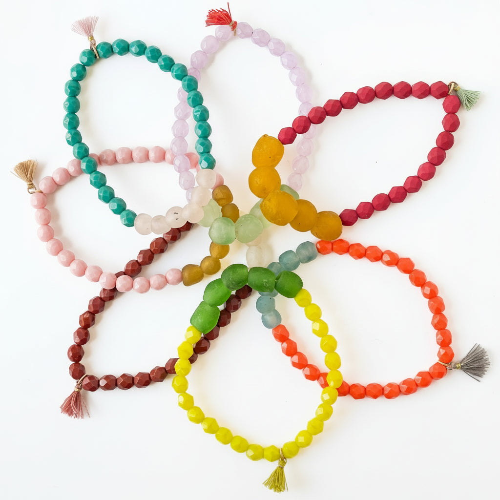 A collection of colorful beaded bracelets with tassels, displayed in a flower-like pattern on a white background.
