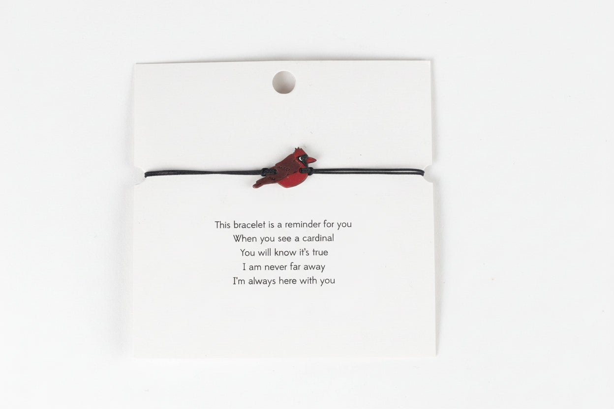 Bracelet with cardinal charm on a card with a gentle reminder.
