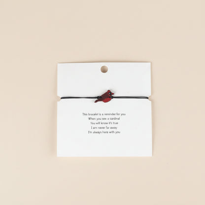 Bracelet with cardinal charm on a card with a gentle reminder.