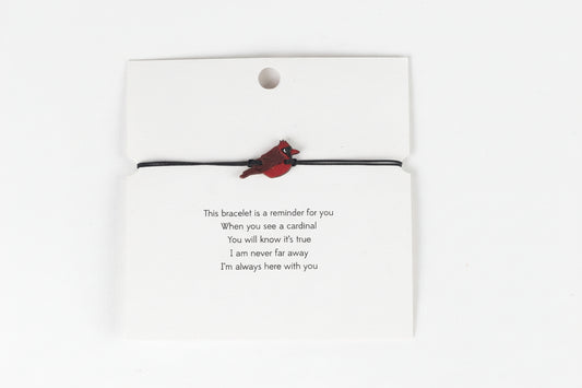 Bracelet with cardinal charm on a card with a gentle reminder.