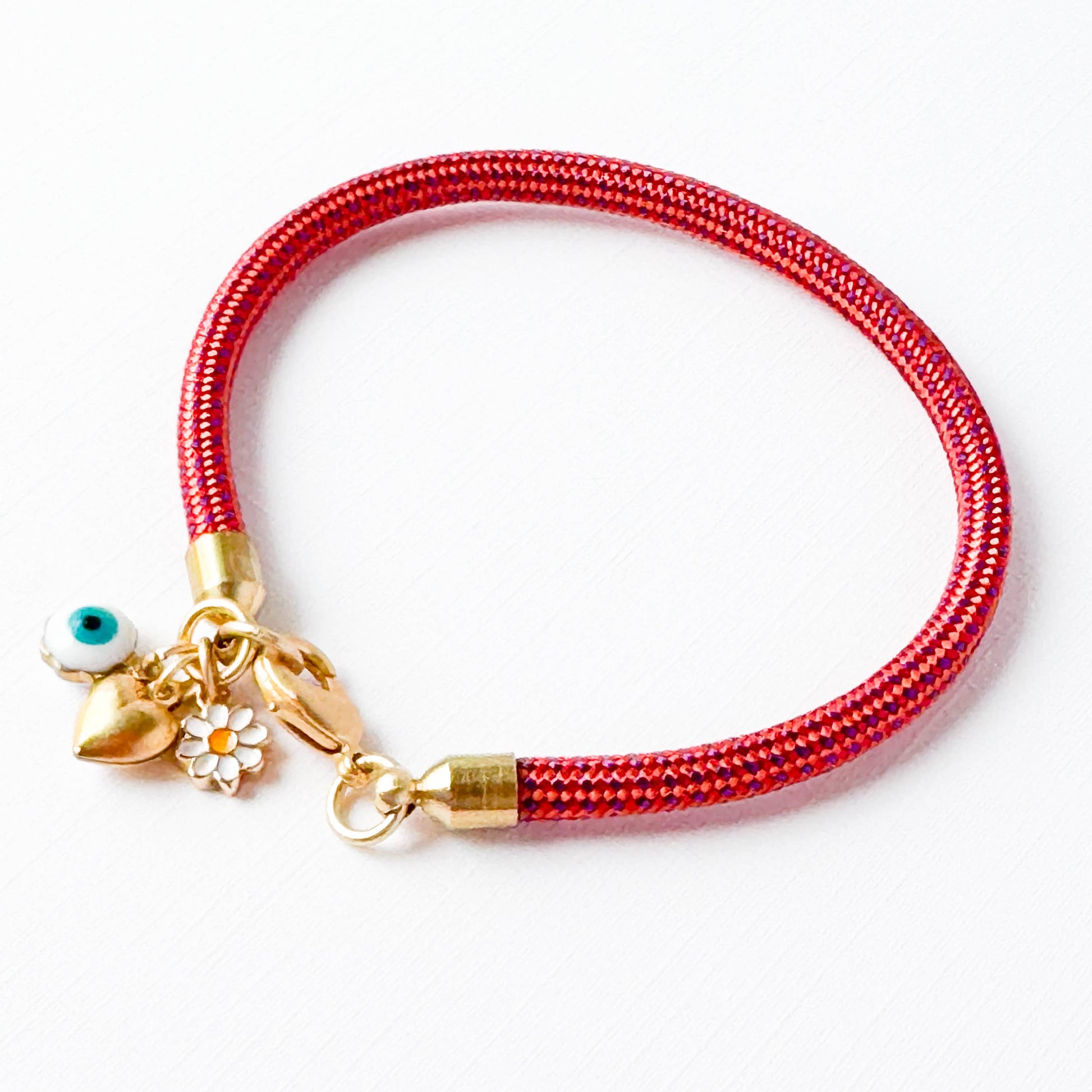 Red paracord charm bracelet with evil eye, daisy, and gold heart on white background