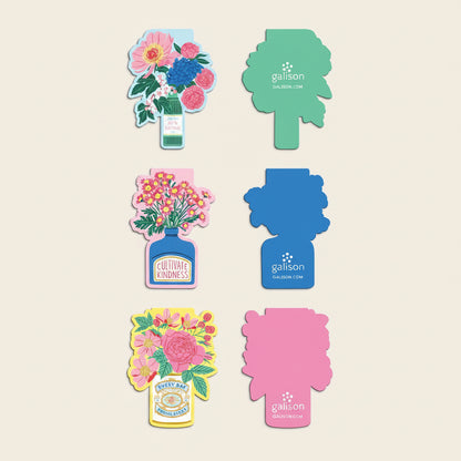 Colorful magnetic bookmarks with floral designs and branding on a white background