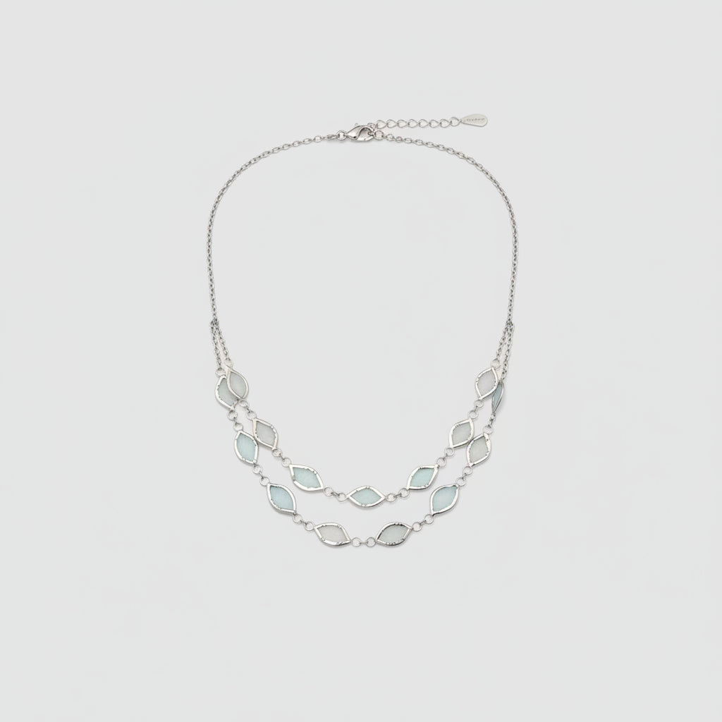 Necklace with light blue gemstones worn by a person against a neutral background