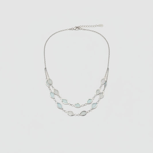 Necklace with light blue gemstones worn by a person against a neutral background