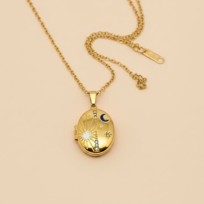 Gold locket necklace on a hand with a plain background