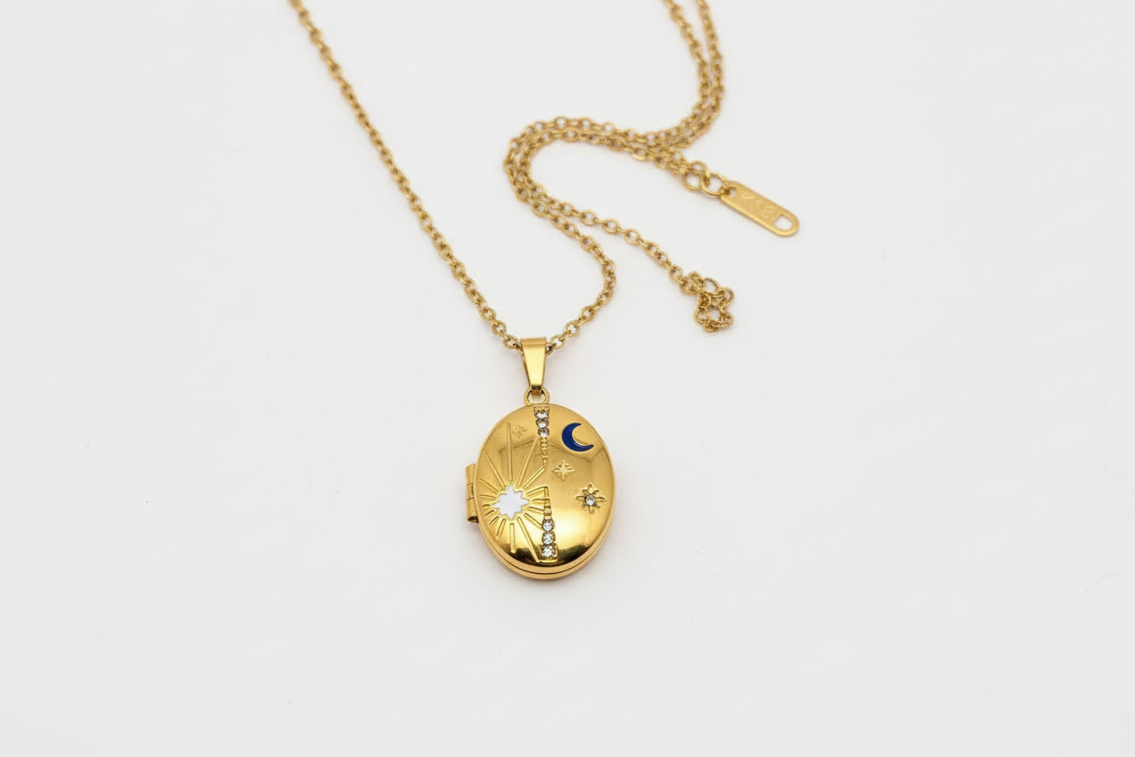 Gold locket necklace on a hand with a plain background
