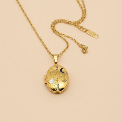 Gold locket necklace on a hand with a plain background