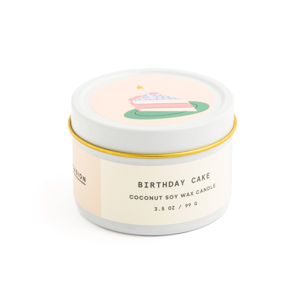 Birthday cake scented candle in white tin with corked vial of colorful matchsticks, packaged in a clear vinyl gift box.