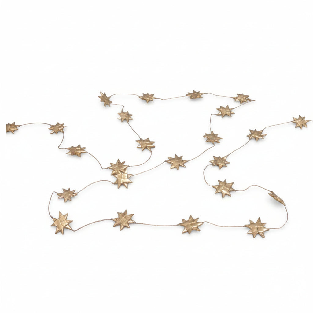 A gold palm leaf star garland displayed on a white background