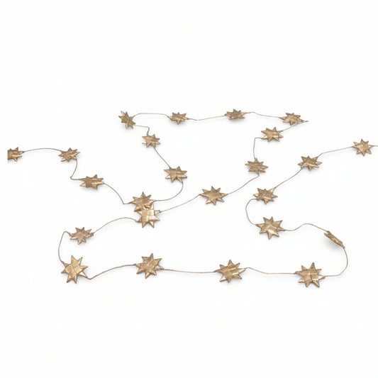 A gold palm leaf star garland displayed on a white background