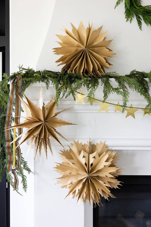 Decorative mantel with gold paper stars and greenery
