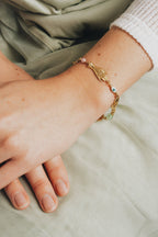 Delicate charm bracelet styled with a linen dress and dainty rings