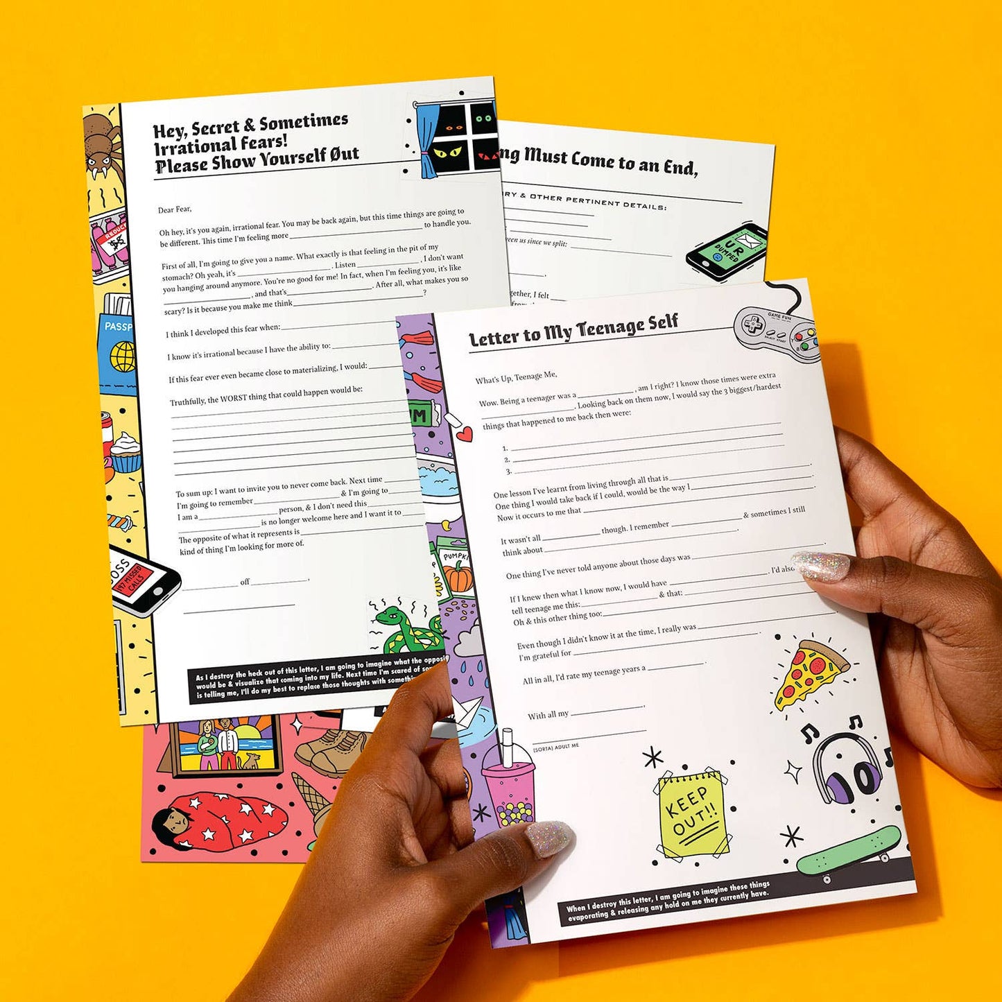 Hand holding a colorful letter writing sheet with various designs on a yellow background