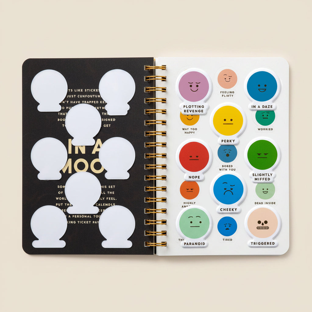 Spiral‑bound notebook shown with assorted emoticon stickers in different moods.