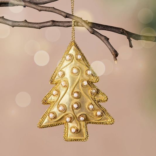 Gold Christmas tree ornament hanging on a branch with a blurred light holiday background