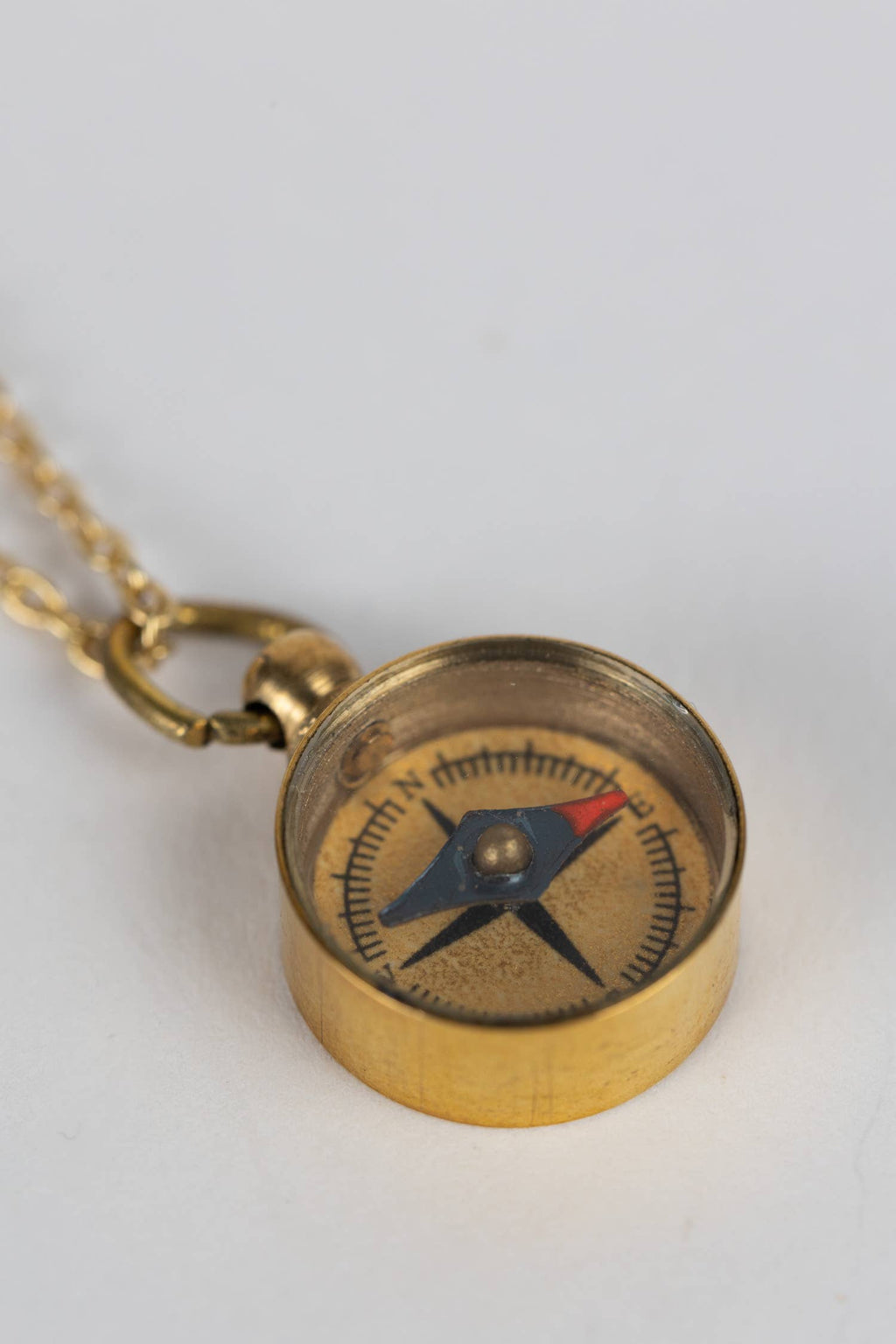 Brass compass necklace on a white background
