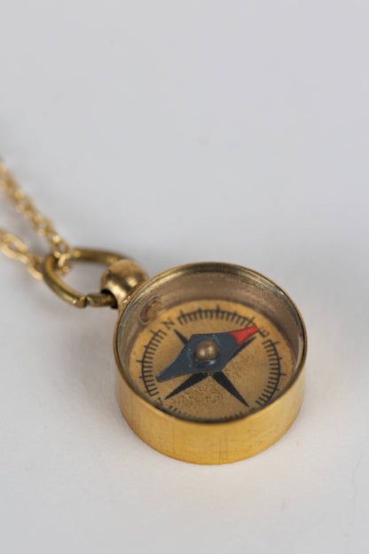 Brass compass necklace on a white background