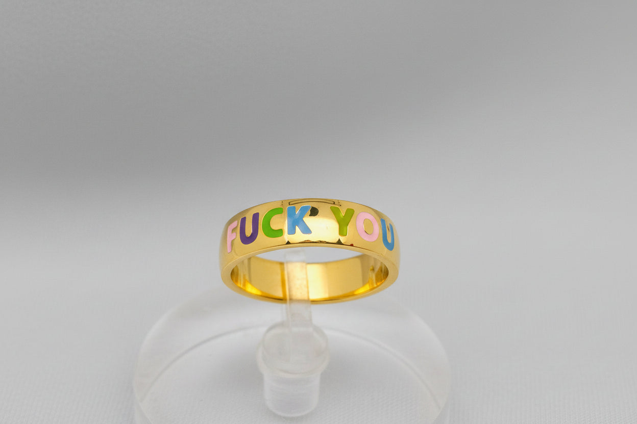 Gold ring with colorful letters spelling 'FUCK YOU' on a white background