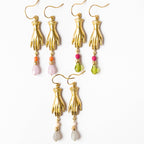 Gold hand-shaped earrings with colorful beads on a white background