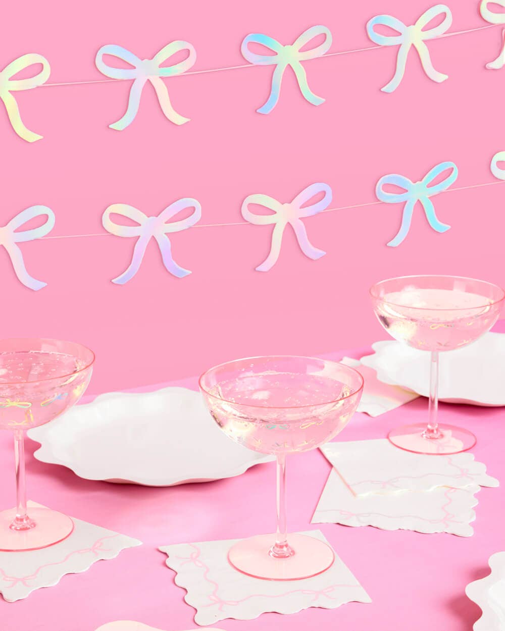Glam pink bow garland with iridescent foil finish—4 strands, 12' each—perfect for adding sparkle to bridal showers, bachelorette parties, and baby showers.