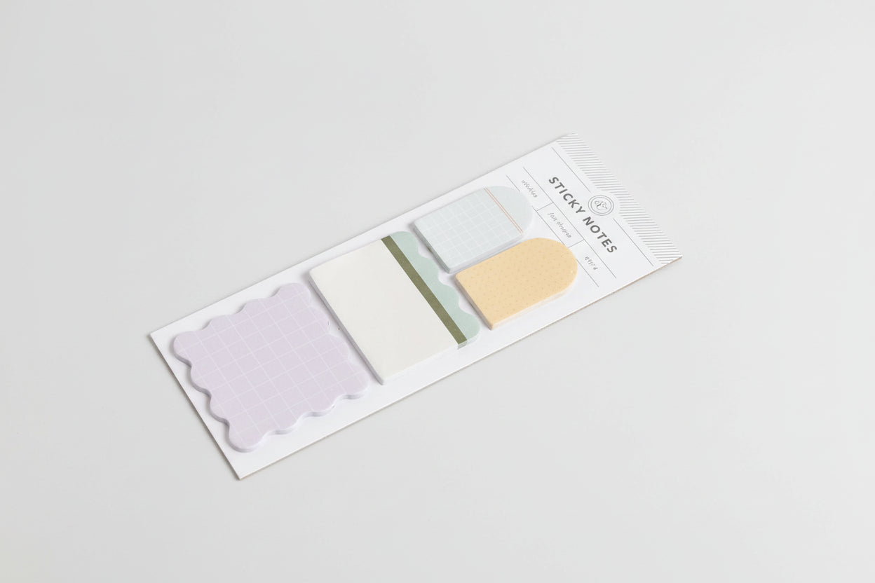 Set of sticky notes in various colors with a clear plastic cover on a white background