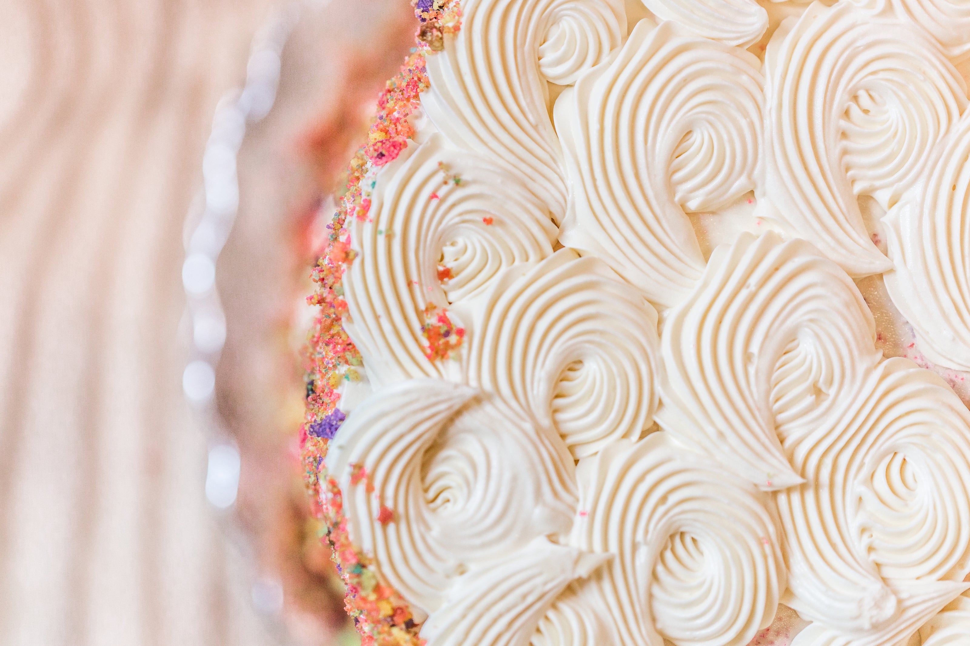Close up of birthday cake with swirls of icing and sprinkles