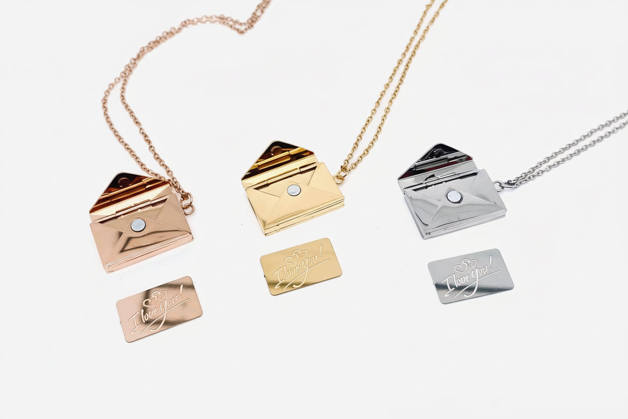 Set of gold and silver envelope-shaped pendants on a white background