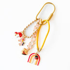 Rainbow bag charm keychain with pink beads, unicorn, and heart against white background