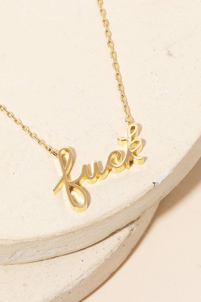 Close up view of the gold-dipped “fuck” handwritten pendant necklace