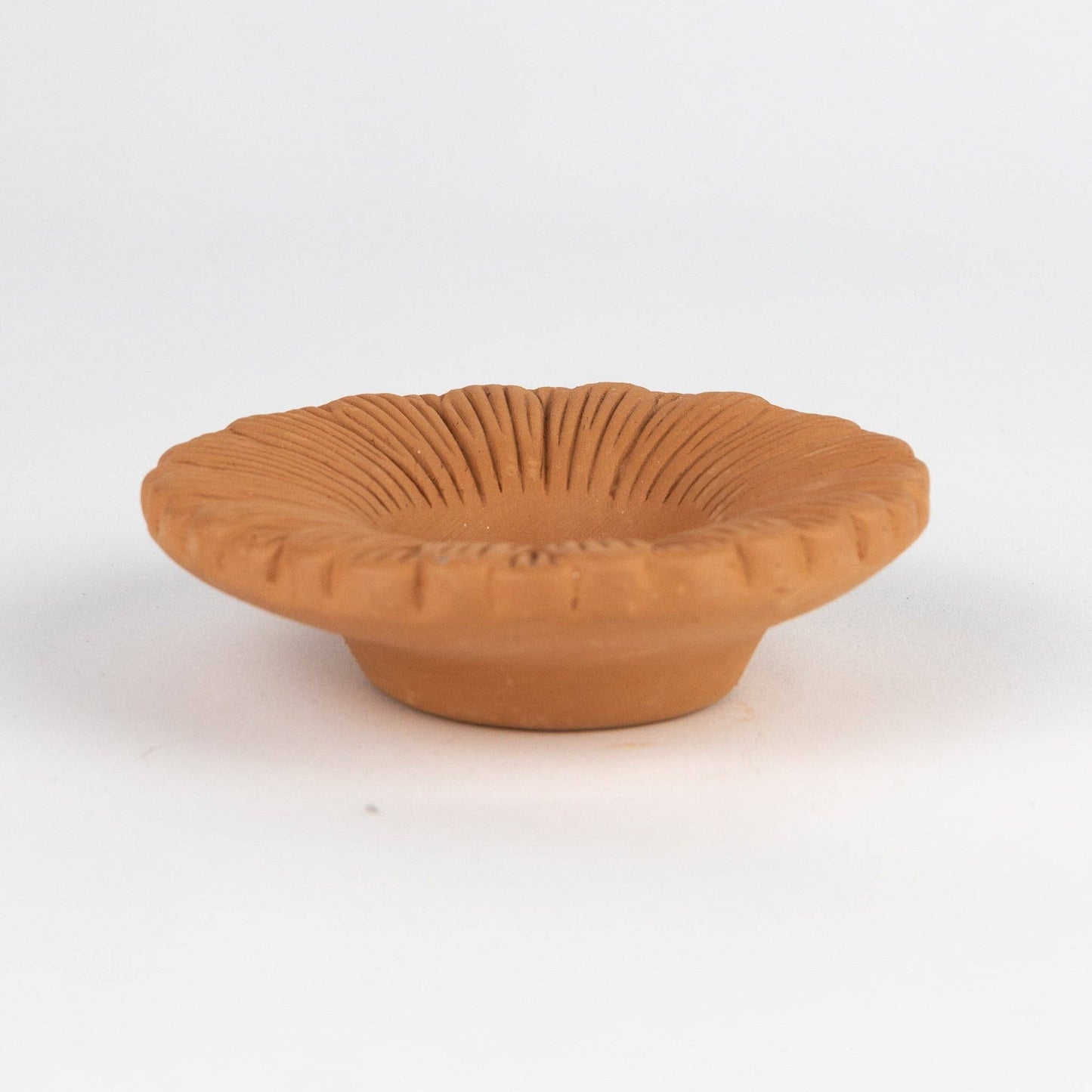 Terracotta bowl with textured surface on a white background