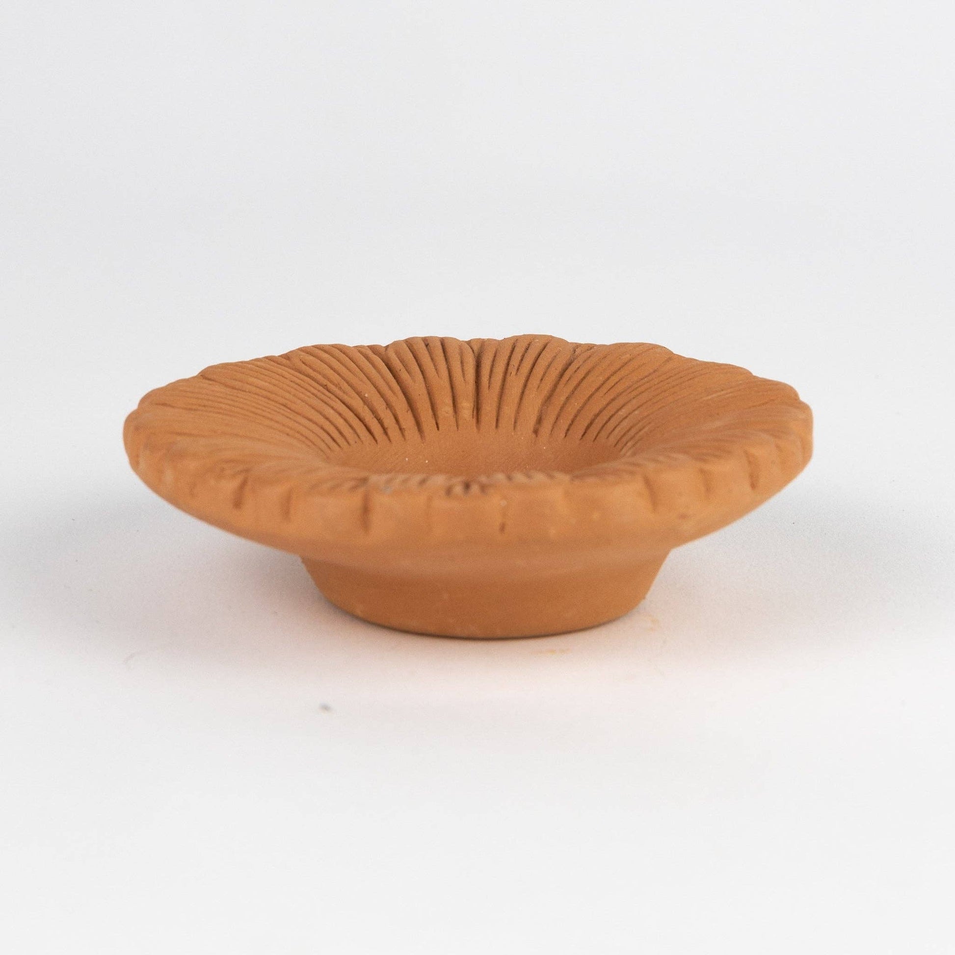 Terracotta bowl with textured surface on a white background