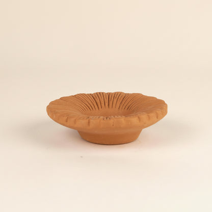 Terracotta bowl with textured surface on a white background