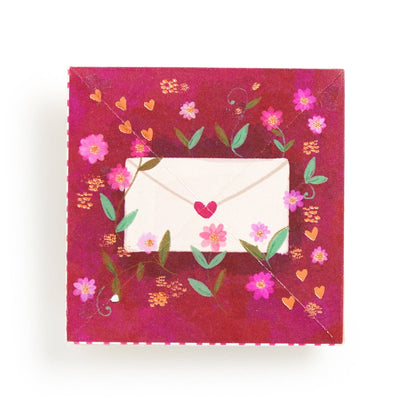 Red card with flowers and a white envelope with a small red heart on a Joy LaForme card