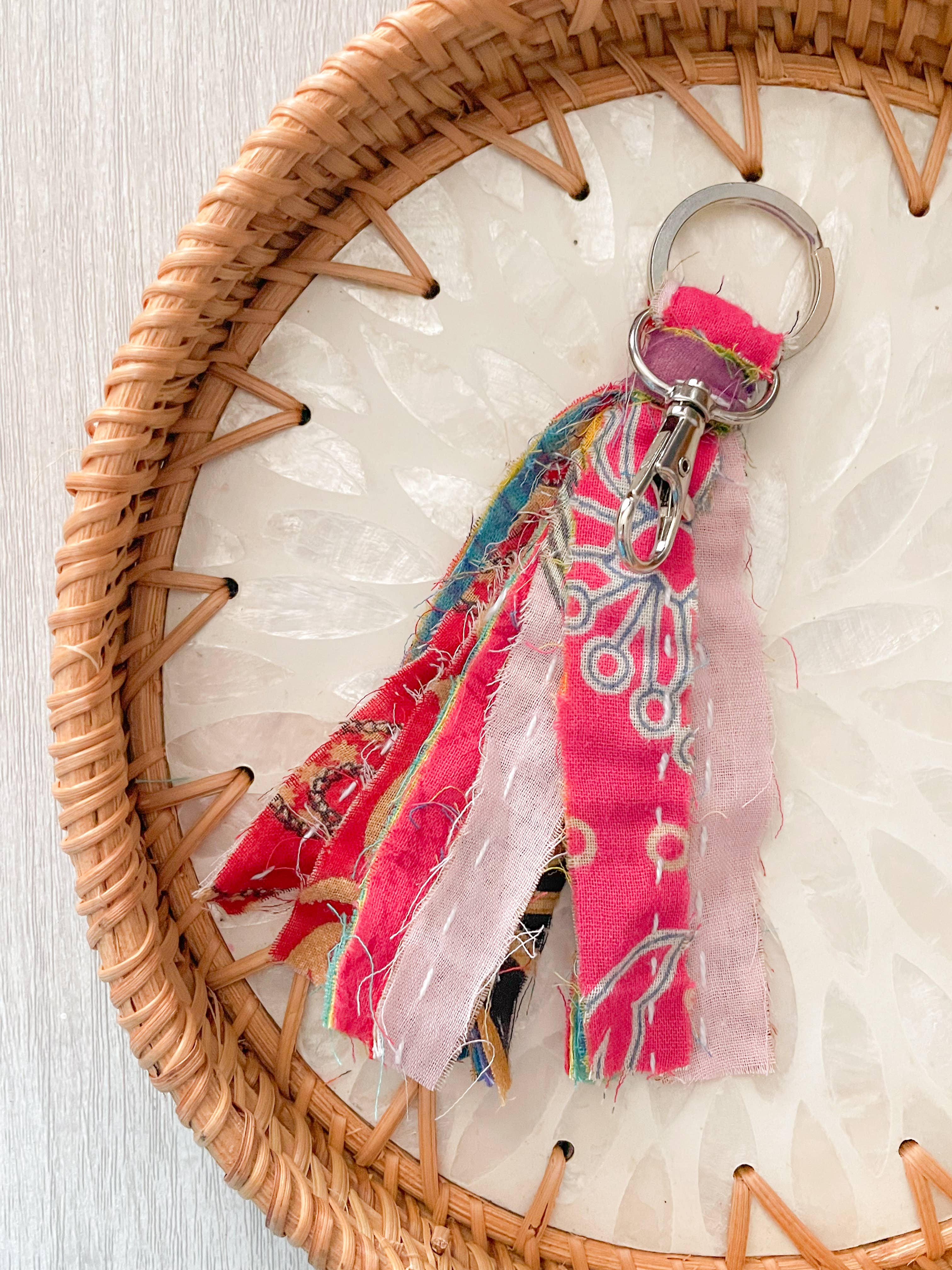 Colorful fabric keychain with a woven basket on a textured surface